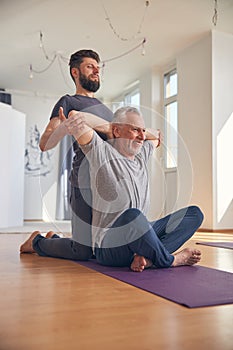 Smiling mature man performing a chest stretch