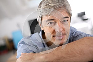 Smiling mature man relaxing at office