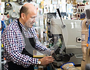 Mature man making duplicates of keys .