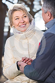 Smiling mature married couple holding hands each other in park