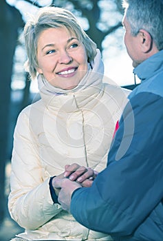 Smiling mature married couple holding hands each other in park