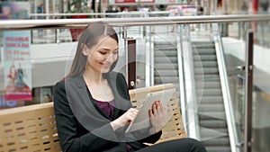 Smiling mature professional businesswoman in office. Holding a digital tablet . Woman brunette in airport or shopping
