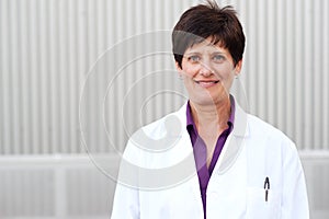 Smiling mature professional woman in labcoat
