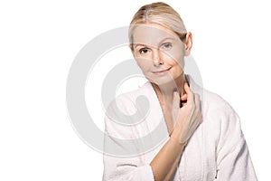 smiling mature woman in bath robe touching neck