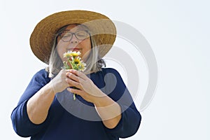 smiling mature woman with a bouquet of daisies in her hands
