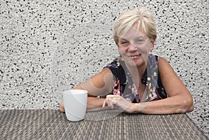 Smiling mature woman with coffee with copy space