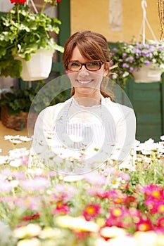 Smiling Mature Woman Florist At Flower Shop