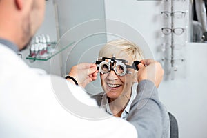 Smiling mature woman having eyesight exam and diopter measurement