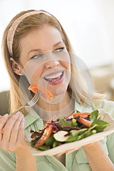 Smiling Mature Woman Having Salad At Home