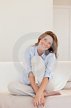 Smiling mature woman sitting on couch