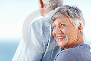 Smiling mature woman spending time with man outdoors. Portrait of happy mature woman smiling while standing behind man