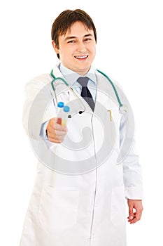 Smiling medical doctor holding test tubes in hand