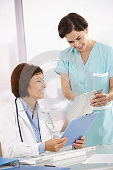 Smiling medical expertise working with assistant