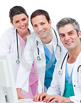 Smiling medical team working at a computer