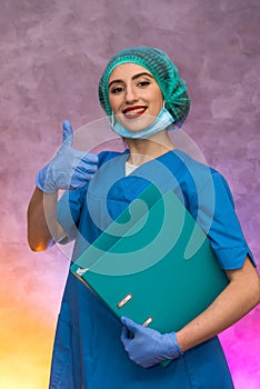 Smiling medical worker holding big folder. Woman in medical uniform posing in hospital