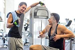 Smiling men exercising on gym machine
