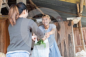 Smiling men holding plastic bags given to female buyer