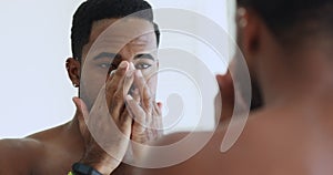 Smiling metrosexual african man applying nose strip cleansing facial pores