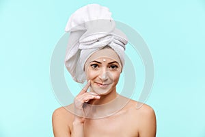 Smiling mid 30s woman with moisturizing cream on her face. Photo of attractive caucasian woman with healthy skin.