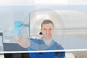 Worker Cleaning Glass Window With Squeegee