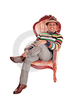 Smiling middle age man in armchair.