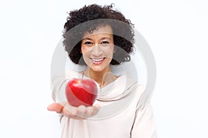 Smiling middle age woman holding red apple against white background