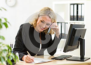 Smiling middle-aged business woman working in