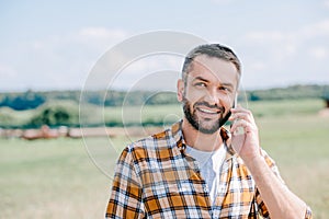smiling middle aged farmer talking by smartphone photo