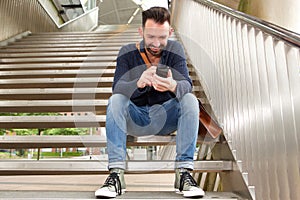 Smiling middle aged guy using mobile phone