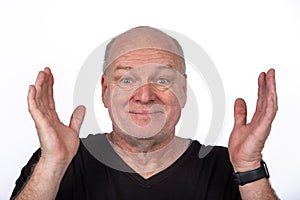 Smiling Middle-Aged Man in Black T-Shirt with Hands Raised on White Background - Happy Lifestyle Concept