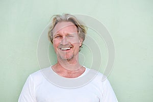 Smiling middle aged man standing against green background