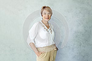 Smiling middle aged mature woman looking at camera. Happy old lady posing indoor