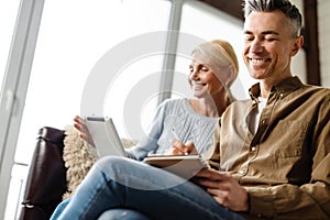 Smiling middle aged white couple relaxing on a couch