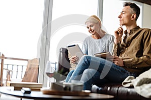 Smiling middle aged white couple relaxing on a couch