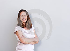 Smiling middle aged woman against white wall