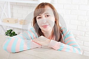 Smiling middle-aged woman looking at camera at home background. Woman`s face close up. Mock up and copy space. Menopause