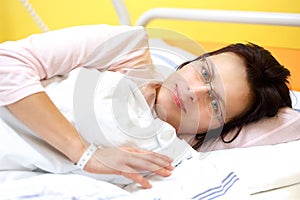 Smiling middle-aged woman lying in hospital