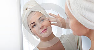 Smiling middle aged woman satisfied with her nature beauty. Cosmetic facial care concept