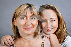 Smiling middle-aged young mother and daughter