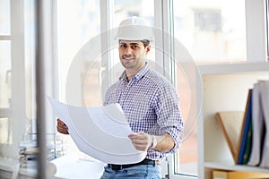 Smiling Middle-Eastern Engineer Holding Plans