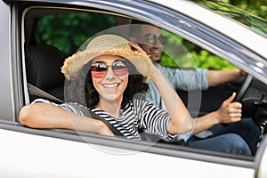 Smiling middle-eastern lovers going to beach by car