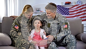 Vojenský rodičia pozerá na roztomilý americký vlajka 