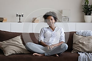 Happy ethnic female renter relax watching TV photo
