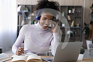 Smiling millennial african woman watching educational lecture.