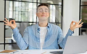 Smiling millennial caucasian guy manager with laptop rest at table, meditating