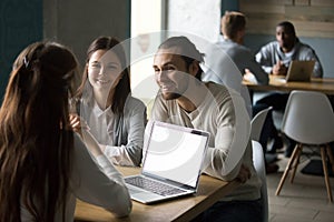 Smiling millennial couple meeting realtor or insurance broker in