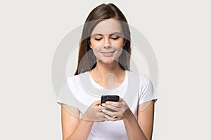 Smiling millennial girl using modern smartphone browsing internet