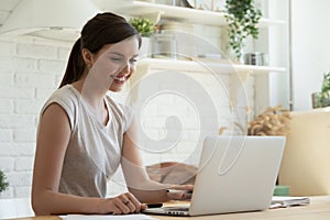 Smiling millennial girl watch webinar on laptop photo