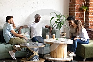 Smiling diverse young people get acquainted in cafe photo