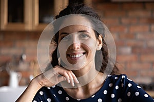 Smiling millennial hispanic woman with perfect skin looking at camera.